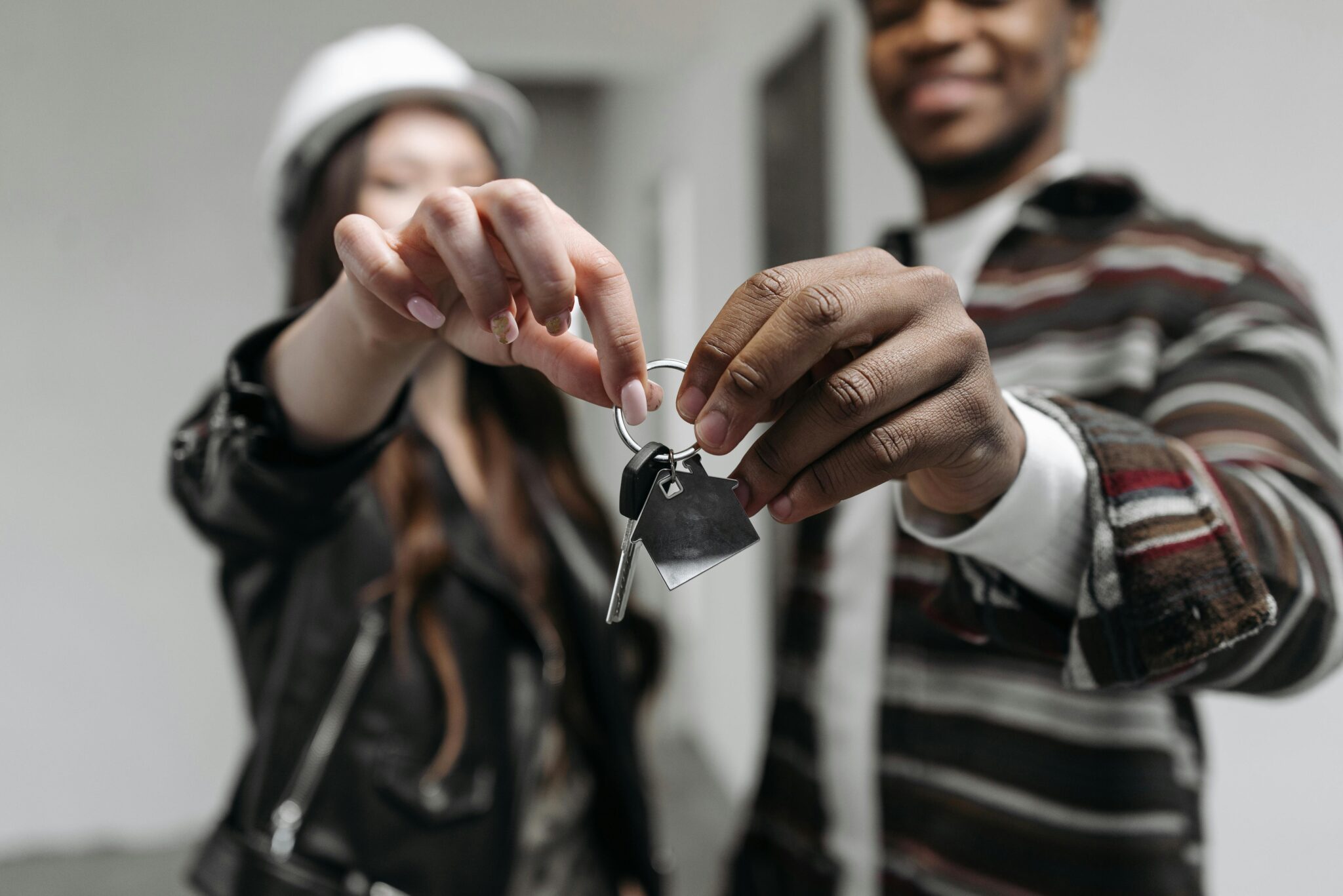 Close-up of a couple joyfully holding keys to their new home, symbolizing new beginnings and home ownership.