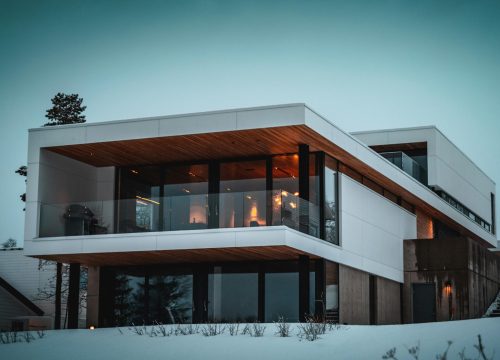 Stunning modern home with glass facade in snowy Troms, Norway, during winter.