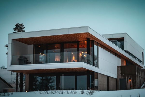 Stunning modern home with glass facade in snowy Troms, Norway, during winter.